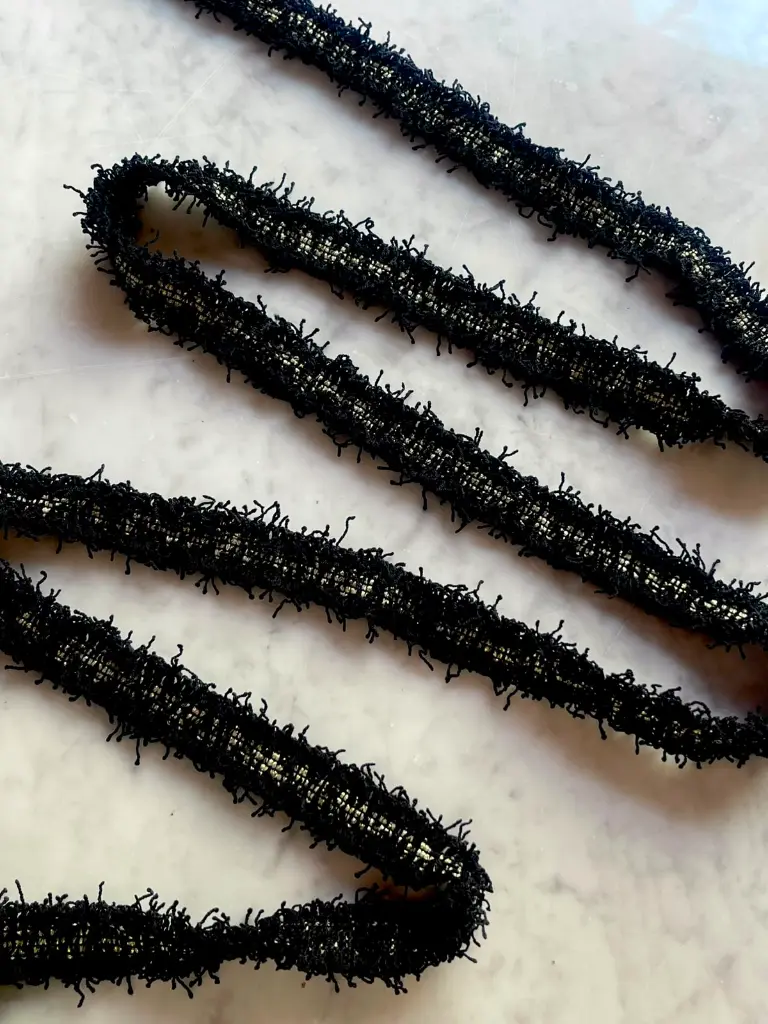 Pasamanería Negro Tipo Tweed con Bordes Deshilachados y Centro Dorado2.webp